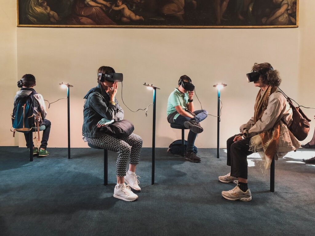 Mehrere Menschen sitzen mit einer VR-Brille in einem Museum.