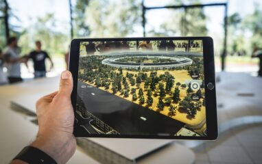 Auf einem Tablet-Bildschirm erscheinen mittels AR virtuelle Elemente auf einem Tisch.
