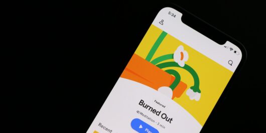 Eine Mental-Health-App zeigt auf einem Smartphone eine Meditation zum Thema "Burned Out" an.