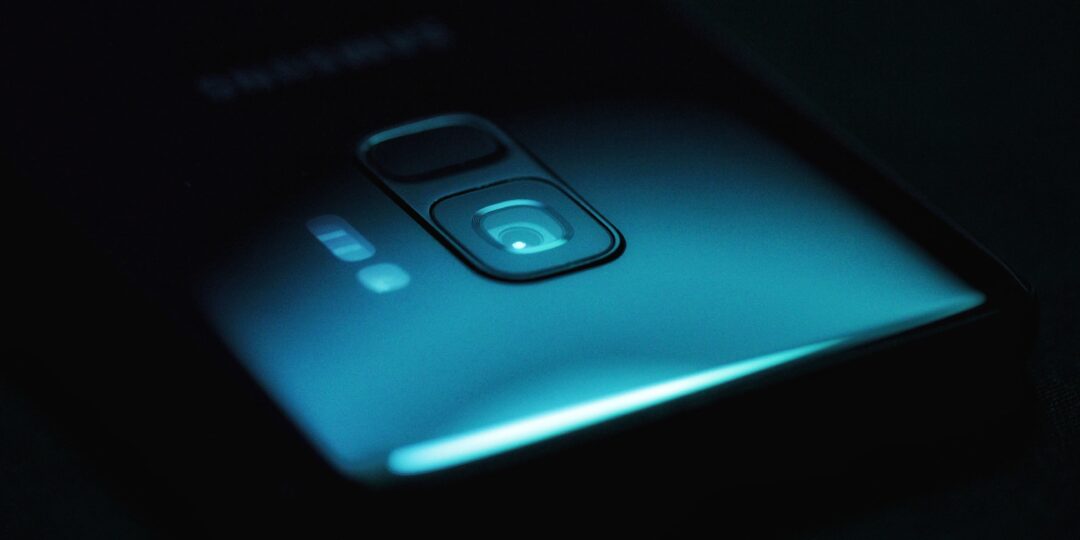 Die Rückseite eines Smartphones in dunkler Umgebung. Bild: Jonah Pettrich / Unsplash